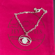 Evil Eye Dangling Bracelet Medium - Silver – handcrafted silver charm bracelet by Jey Jewels by Divya on pink background