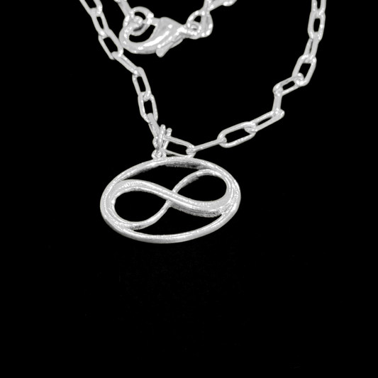 Cosmic Infinity Charm Pendant Necklace Small - Silver – elegant pendant necklace with spiritual meaning by Jéy Jewels by Divya on bkack background zoomed in shot