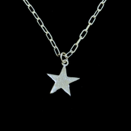 Silver star pendant necklace on a black background by Jéy Jewels by Divya zoomed in shot