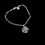 Silver bracelet with a tree-of-life charm on a black background by Jéy Jewels by Divya