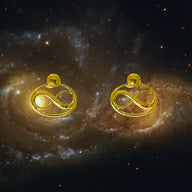 Cosmic Infinity Charm + Studs Earrings Small - Gold – symbolic stud or hoop earrings designed by Jéy Jewels by Divya on cosmic galaxy background